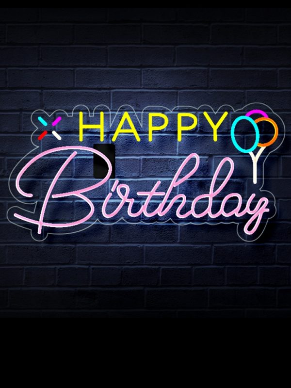 The Happy Birthday Neon Sign - LED Neon Light for Birthday Decorations casts a vibrant glow on the dark brick wall, with Happy in yellow and Birthday in pink cursive. Two colorful balloons enhance the festive atmosphere.