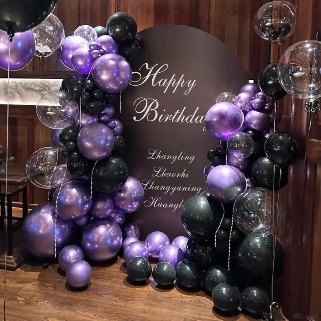 Purple and black birthday balloon arch with clear orbs and custom backdrop for celebration in Singapore