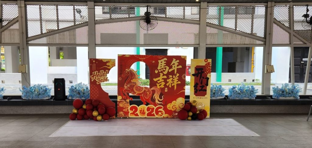 Chinese New Year 2026 event decoration featuring a Year of the Horse themed backdrop with festive red and gold panels and balloon accents.